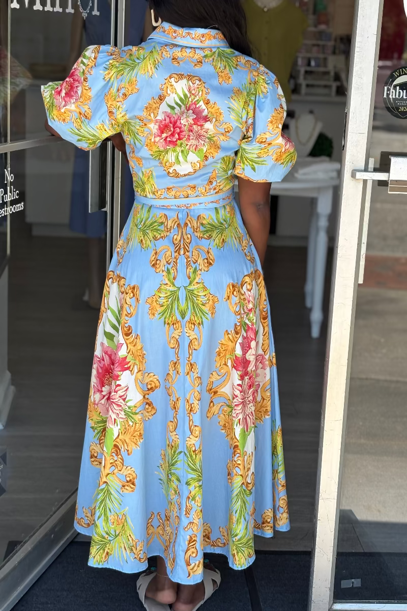 Woman wearing a colorful floral dress with a patterned design in a store - Mirror On Main