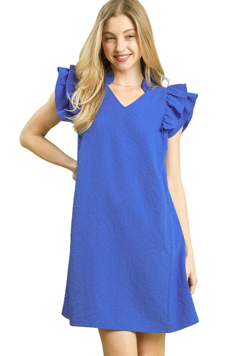 Woman wearing an ocean blue seersucker shift dress with ruffle sleeves and V-neckline — Mirror on Main