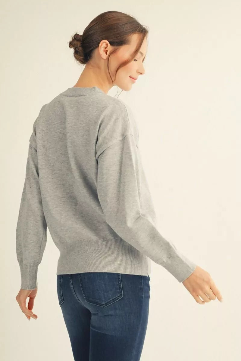 Back view of a heather grey drop shoulder knit sweater with ribbed cuffs and hem – Mirror On Main.