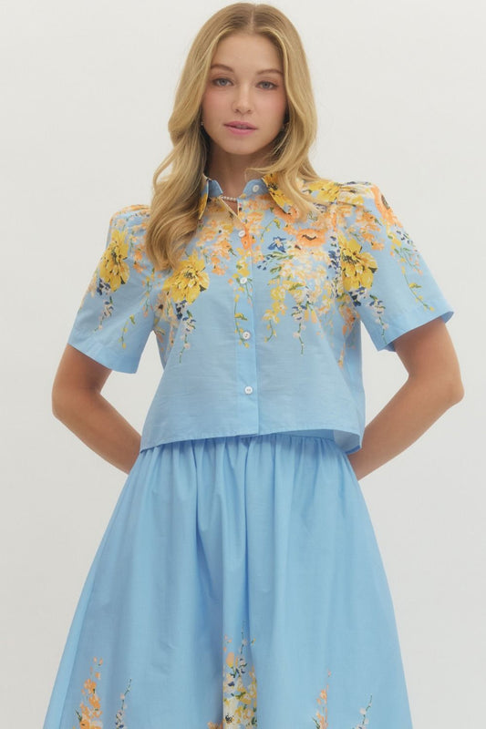 Blue floral short sleeve button-down top with a collared neckline in lightweight cotton fabric.