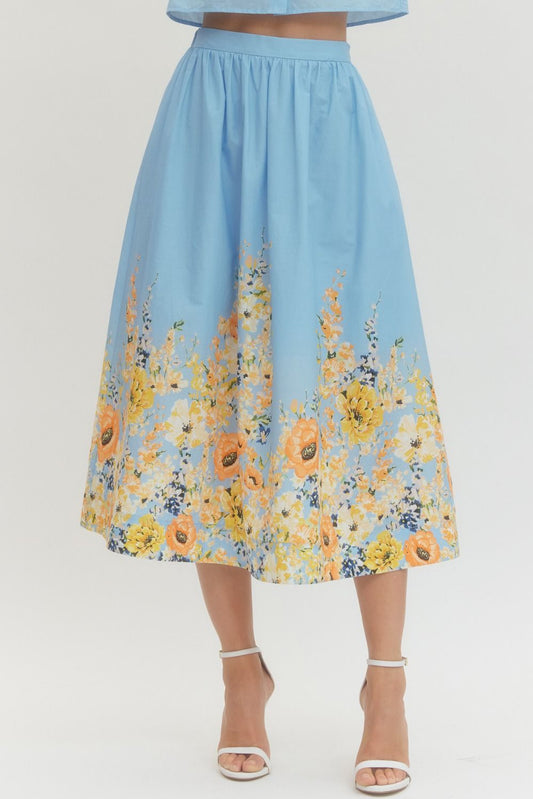 Blue floral midi skirt with pockets and elastic back waistband in lightweight cotton fabric.