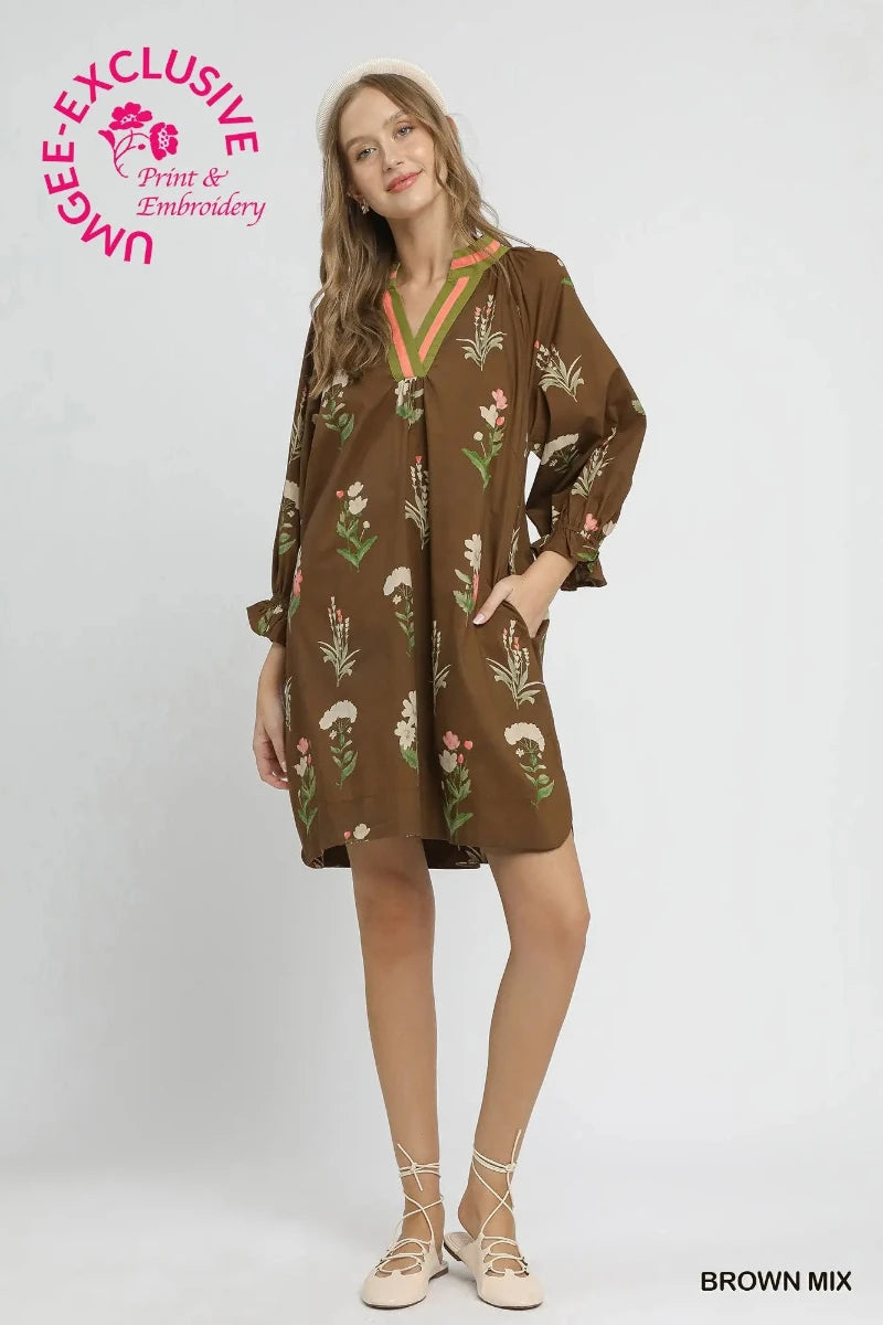 Woman wearing a brown floral tunic dress with contrast V-neckline trim and ruffle sleeve cuffs — Mirror on Main