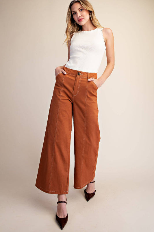 Woman wearing camel high rise wide leg pants with contrast stitch seam detail and button fly closure, styled with brown heels — Mirror on Main