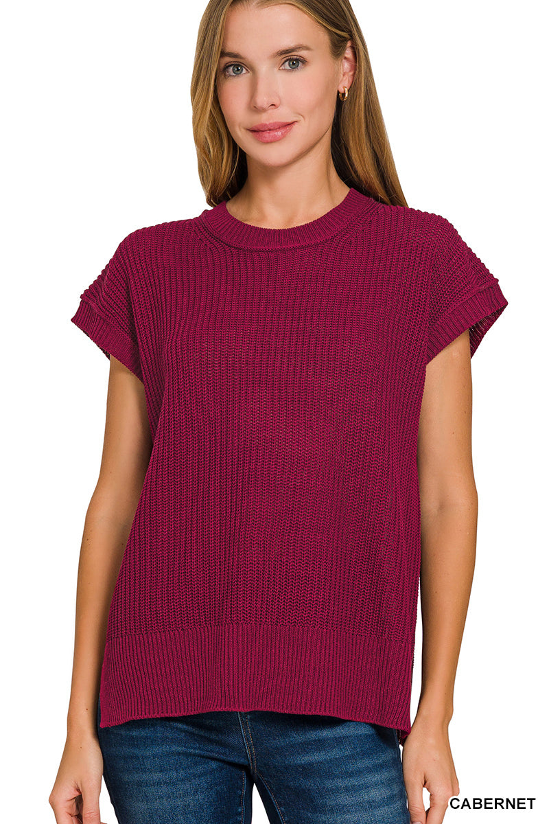 Woman wearing a maroon sweater with short sleeves on a white background