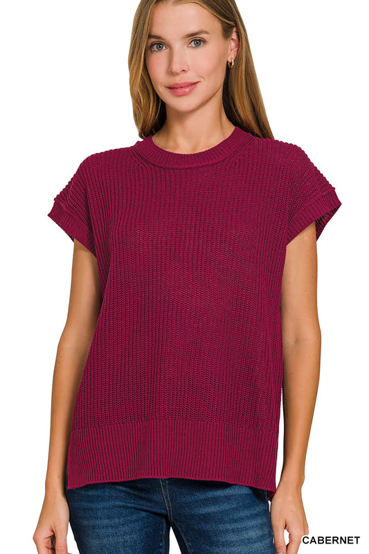 Woman wearing a maroon sweater with short sleeves on a white background
