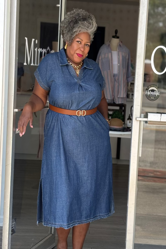 Woman wearing a stone washed denim midi dress with V-notch collar, side slits, and frayed hem detail — Mirror on Main