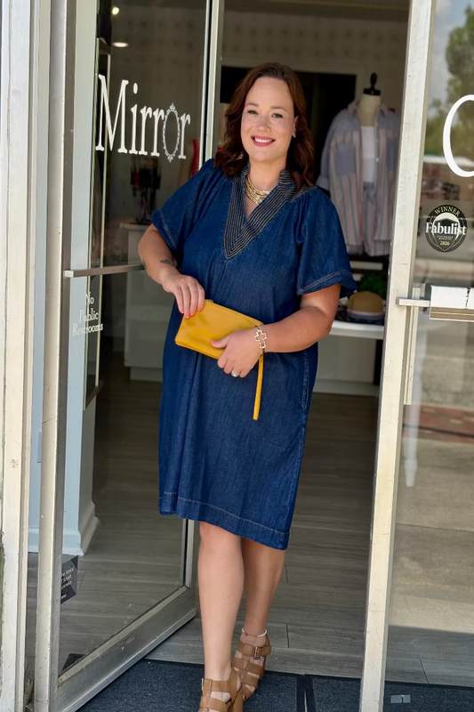 Plus size woman wearing a denim A-line dress with puff sleeves, deep V-neck, and contrast stitching — Mirror on Main