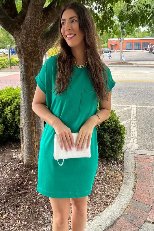 Woman in a green dress standing under a tree on a street corner of Mirror On Main