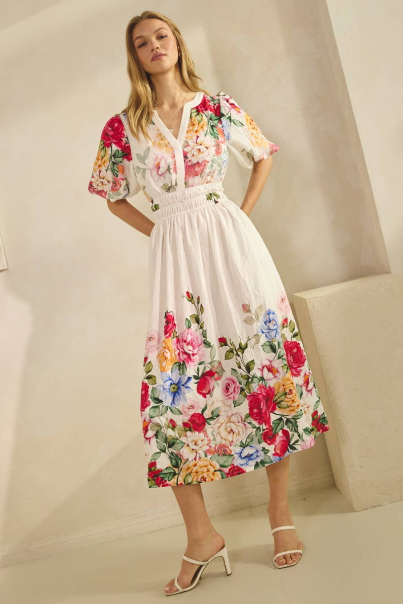 Floral printed midi dress with short sleeves, fitted waist, and flowy skirt, styled with heels.