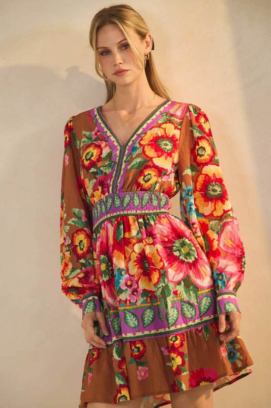 Woman wearing a colorful floral dress with a plain background
