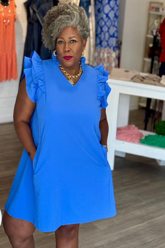 Plus size woman wearing an ocean blue seersucker shift dress with ruffle sleeves and V-neckline — Mirror on Main
