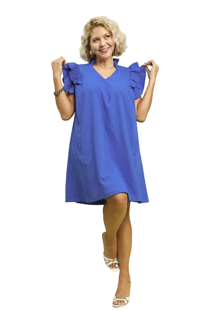 Plus size woman wearing an ocean blue seersucker shift dress with ruffle sleeves and V-neckline — Mirror on Main