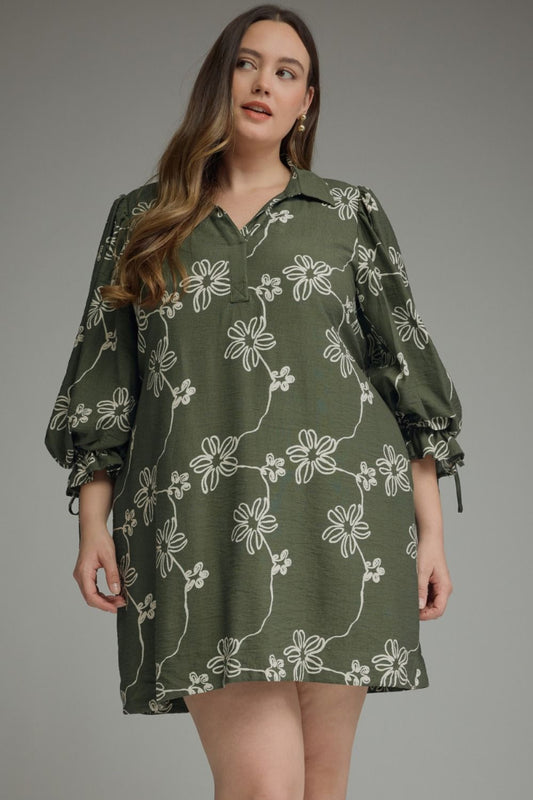 Plus size woman wearing an olive green daisy vine print balloon sleeve mini dress with split collar neckline and adjustable tie cuffs — Mirror on Main