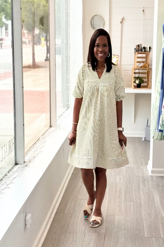 Light olive and cream vertical stripe babydoll mini dress with contrast horizontal border hem, split V-neckline, short puff sleeves with cuffed hem, and side pockets — Mirror on Main