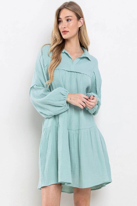Woman wearing a light blue dress against a white background