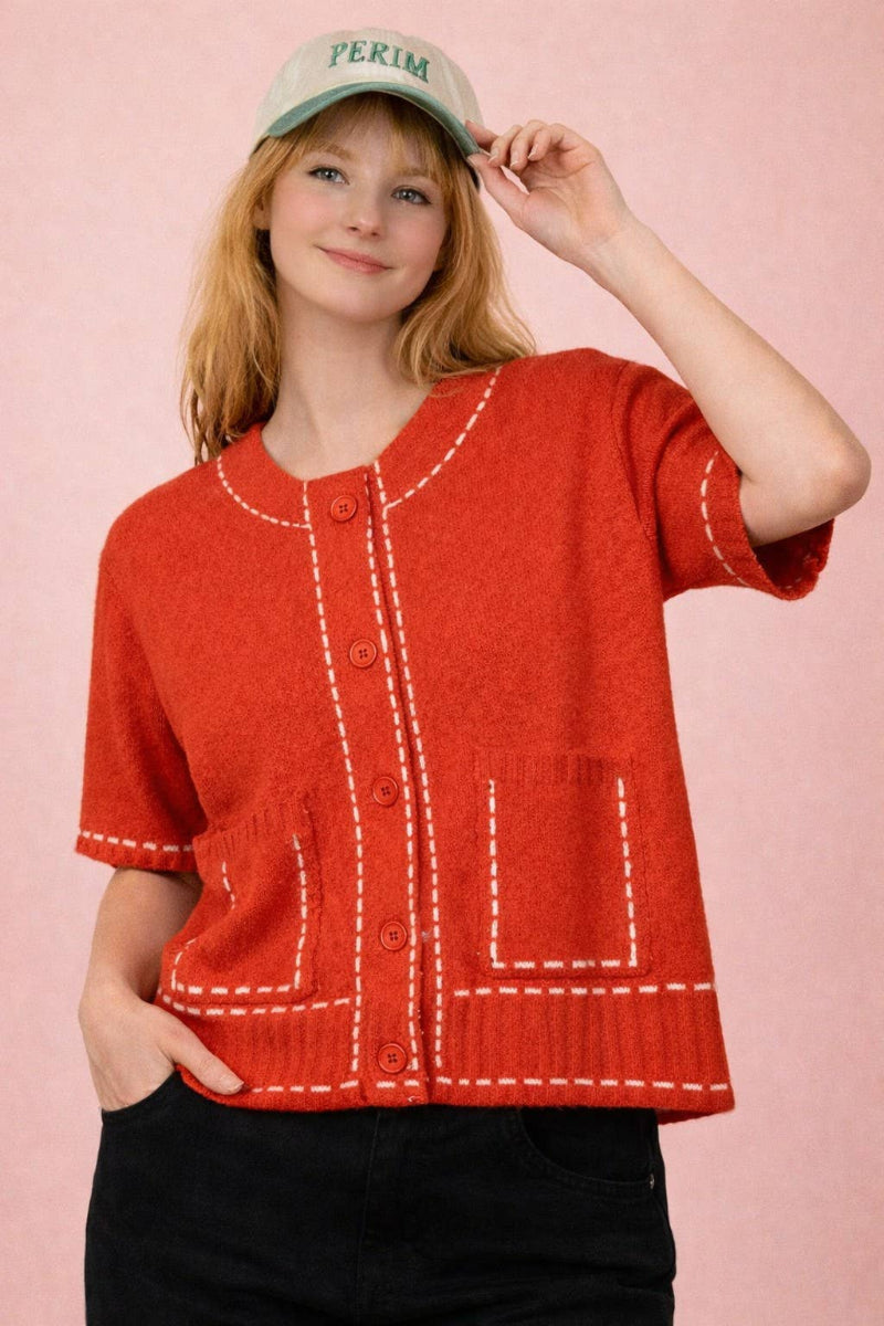Red knit cardigan with contrast white topstitching at neckline, placket, pockets and ribbed hem, round neckline, short sleeves, and front patch pockets — Mirror on Main
