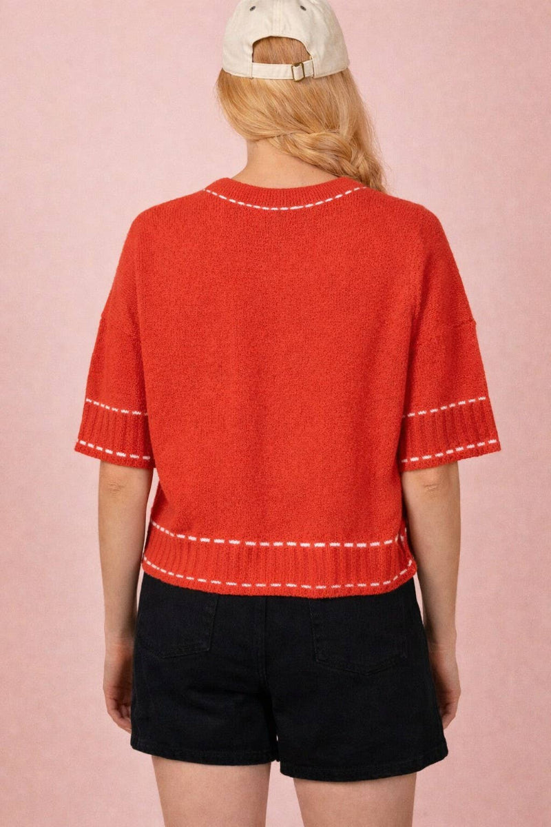 Red knit cardigan with contrast white topstitching at neckline, placket, pockets and ribbed hem, round neckline, short sleeves, and front patch pockets — Mirror on Main