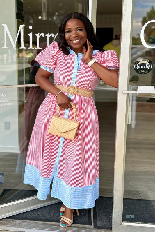 Woman in a pink and blue dress standing outside of Mirror On Main
