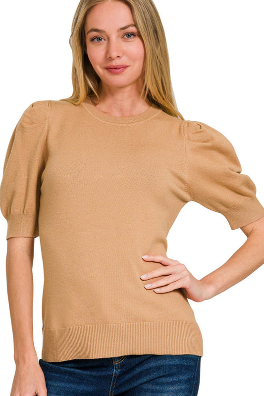Woman wearing a beige sweater with puff sleeves on a white background