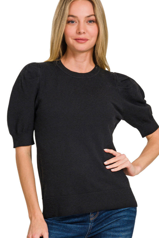 Woman wearing a black sweater with puffed sleeves on a white background