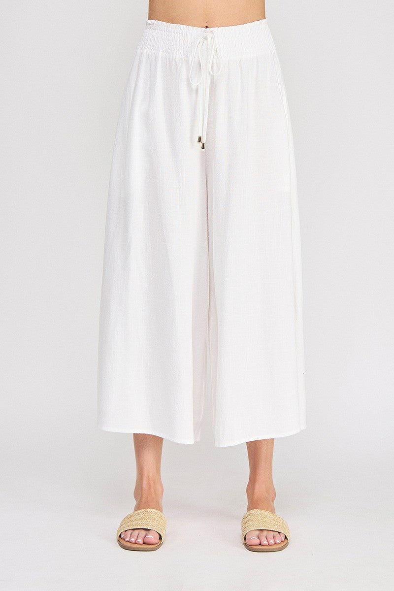 White linen-viscose wide leg capri pants with smocked waistband, drawstring tie with gold-tipped aglets, and side pockets — Mirror on Main