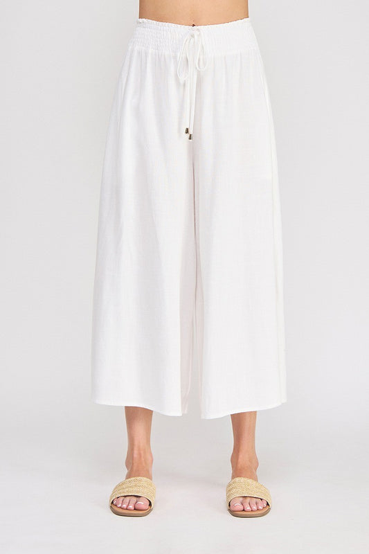White linen-viscose wide leg capri pants with smocked waistband, drawstring tie with gold-tipped aglets, and side pockets — Mirror on Main