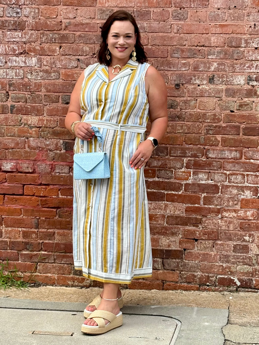 Woman in a striped dress standing against a brick wall Mirror On Main
