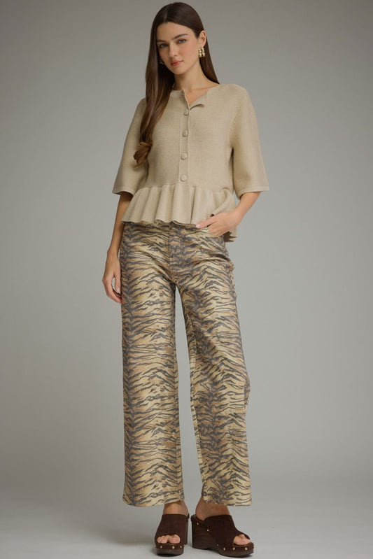 Woman wearing tiger-stripe animal print wide leg pants in camel and charcoal with a cream ruffle-hem knit top and brown platform clogs – Mirror On Main