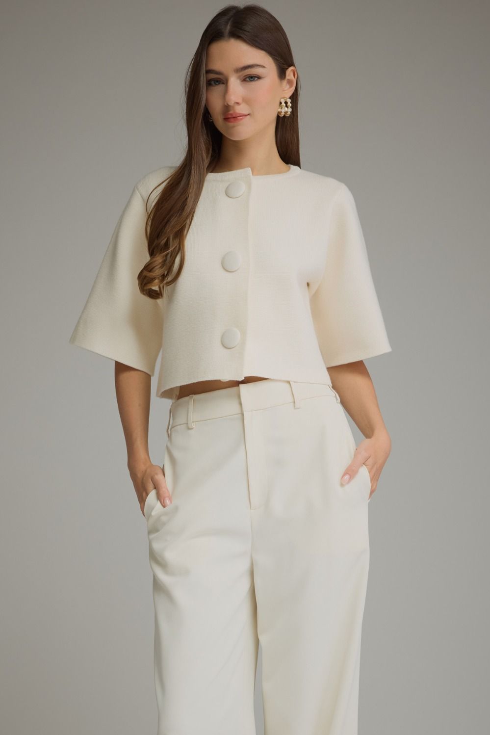 Woman wearing a cream cropped short sleeve sweater jacket with covered buttons – Mirror On Main