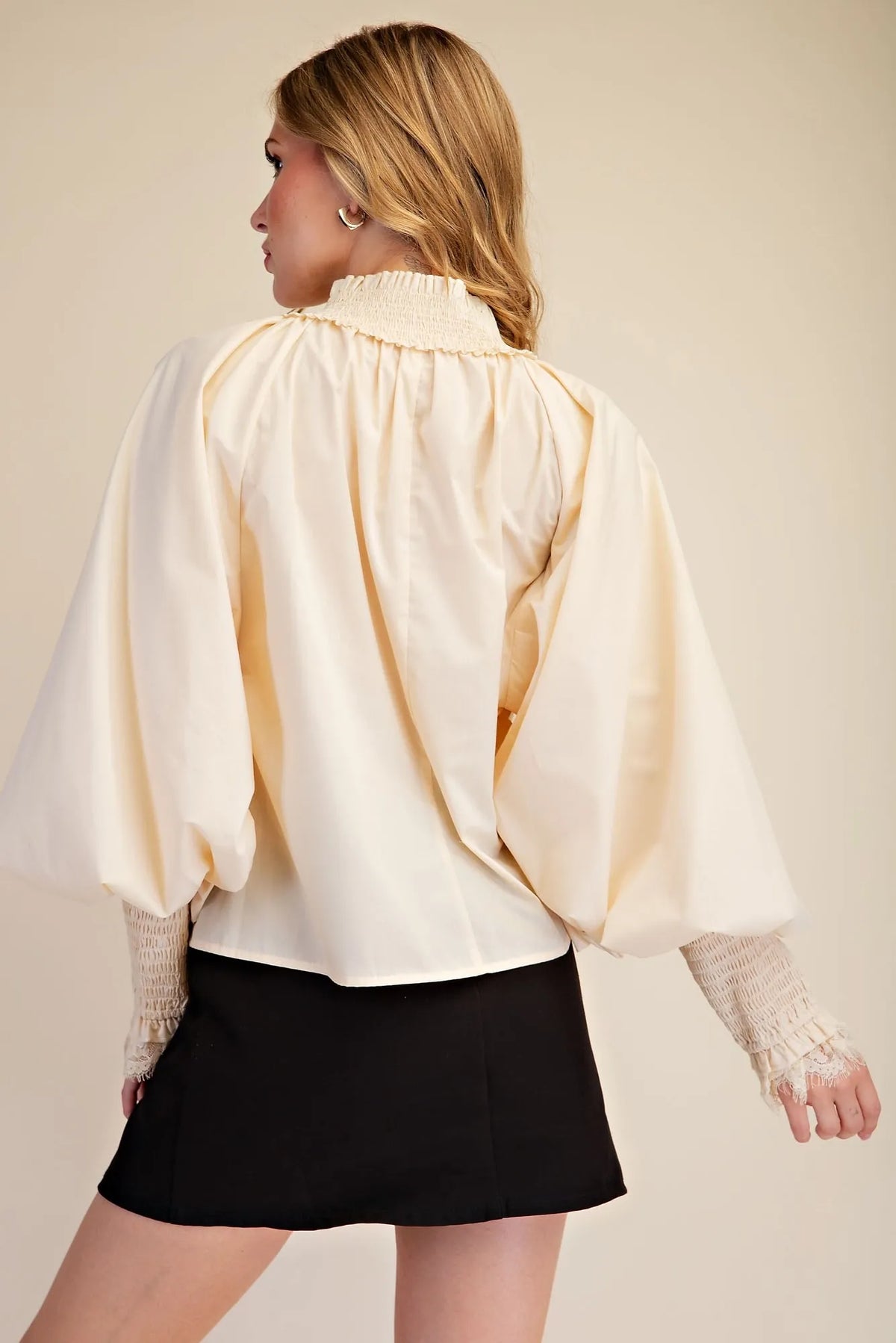 Cream lace puff sleeve blouse with ruffled high neckline, front tie, smocked lace cuffs and scalloped lace hem, modeled back view – Mirror On Main