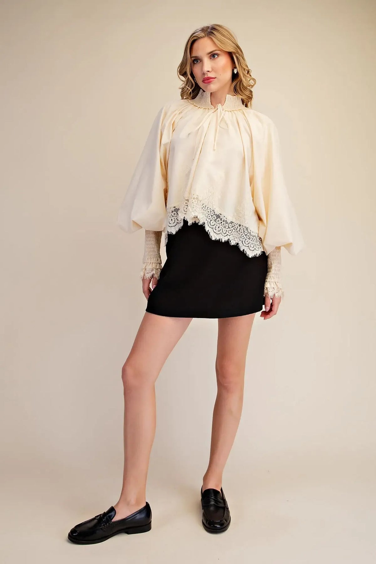 Cream lace puff sleeve blouse with ruffled high neckline, front tie, smocked lace cuffs and scalloped lace hem, modeled full view – Mirror On Main
