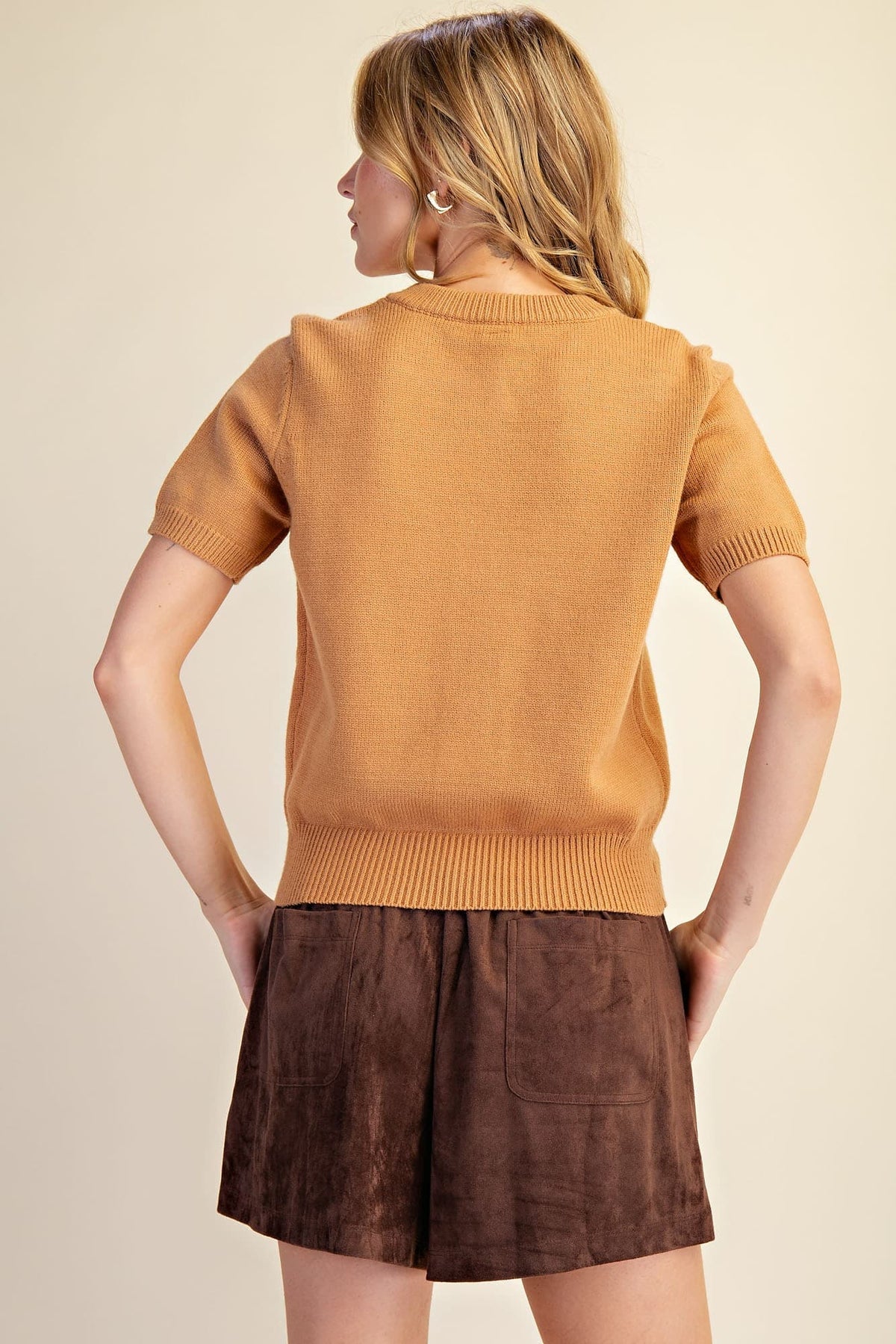 Camel short sleeve knit cardigan with round neckline, gold-tone floral buttons, ribbed cuffs and hem, modeled back view – Mirror On Main